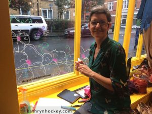 artist at work, kathryn hockey, artist, illustrator, bermondsey street, marys living and giving shop, window, design, springtime, birds, swallows, bees, flowers, here comes the sun, illustration, glass, chalk, pens, drawing, design, london